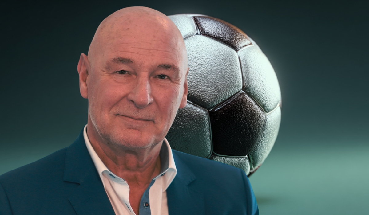 Porträt eines älteren Mannes im Anzug vor einem großen Fußball