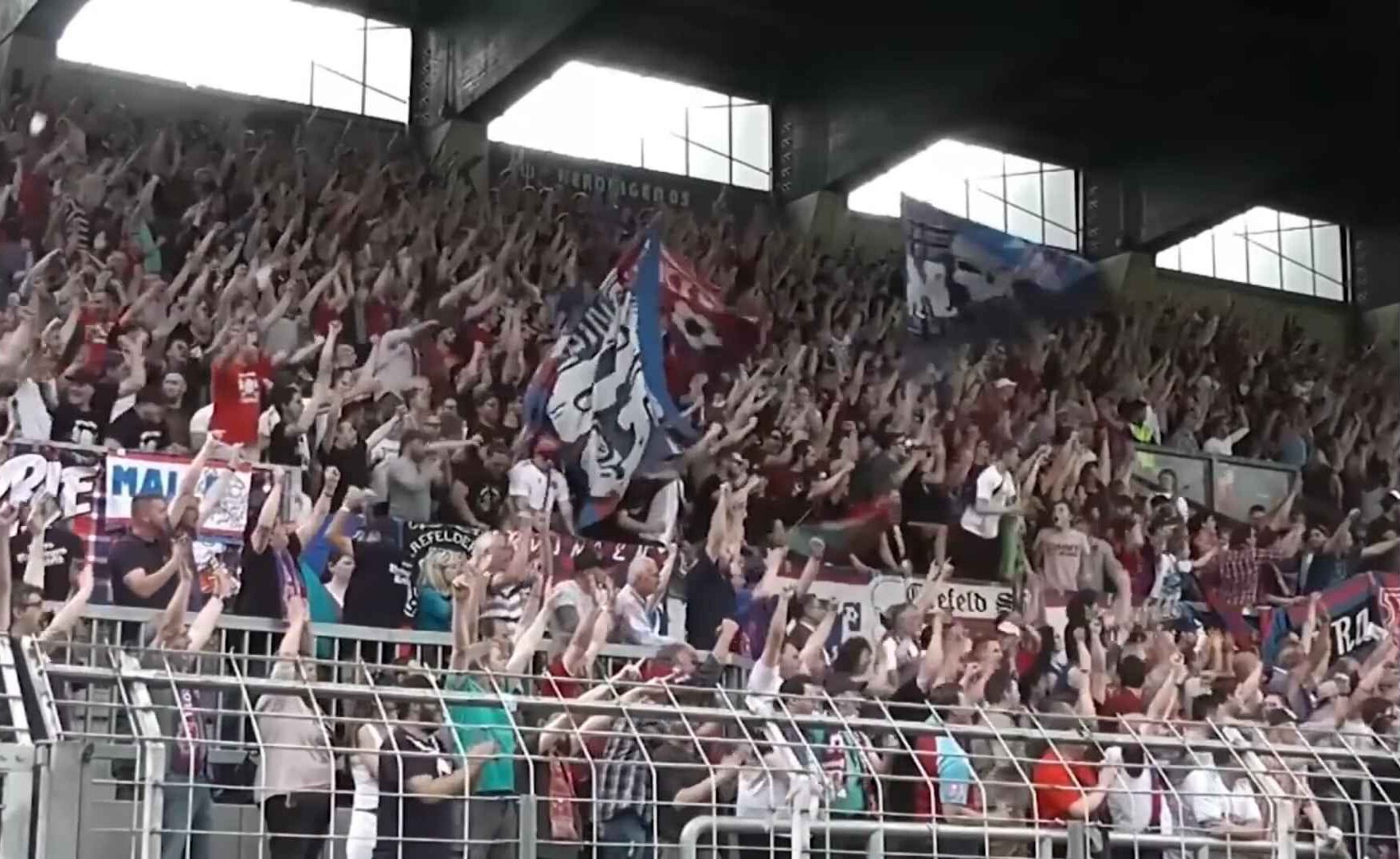 Jubelnde Fußballfans mit Fahnen in einem Stadion